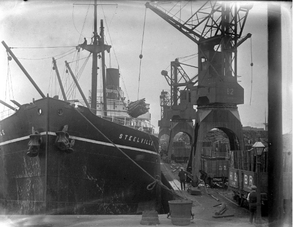 Hydraulic cranes unloading pit-props from SS Steelville in Alexandra Dock in 1926
